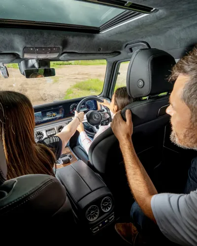 Young driver navigating a 4x4 vehicle over rugged terrain at Mercedes-Benz World's off-road course during a one-hour session.