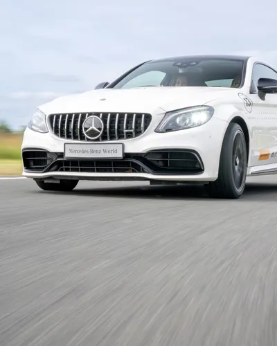 Mercedes-AMG 63 in action on a dynamic driving track at Mercedes-Benz World during a high-performance one-hour experience.