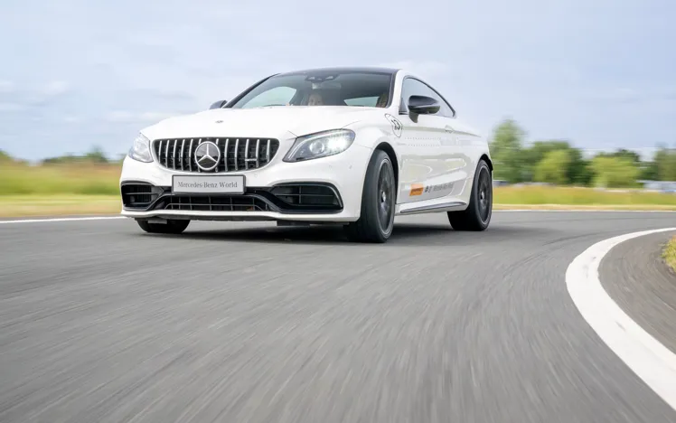 Mercedes-AMG 63 in action on a dynamic driving track at Mercedes-Benz World during a high-performance one-hour experience.