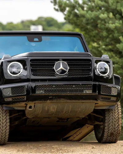 Passenger enjoying a thrilling 4x4 ride through rugged terrain at Mercedes-Benz World's Off-Road Circuit, showcasing vehicle capability and adventure.