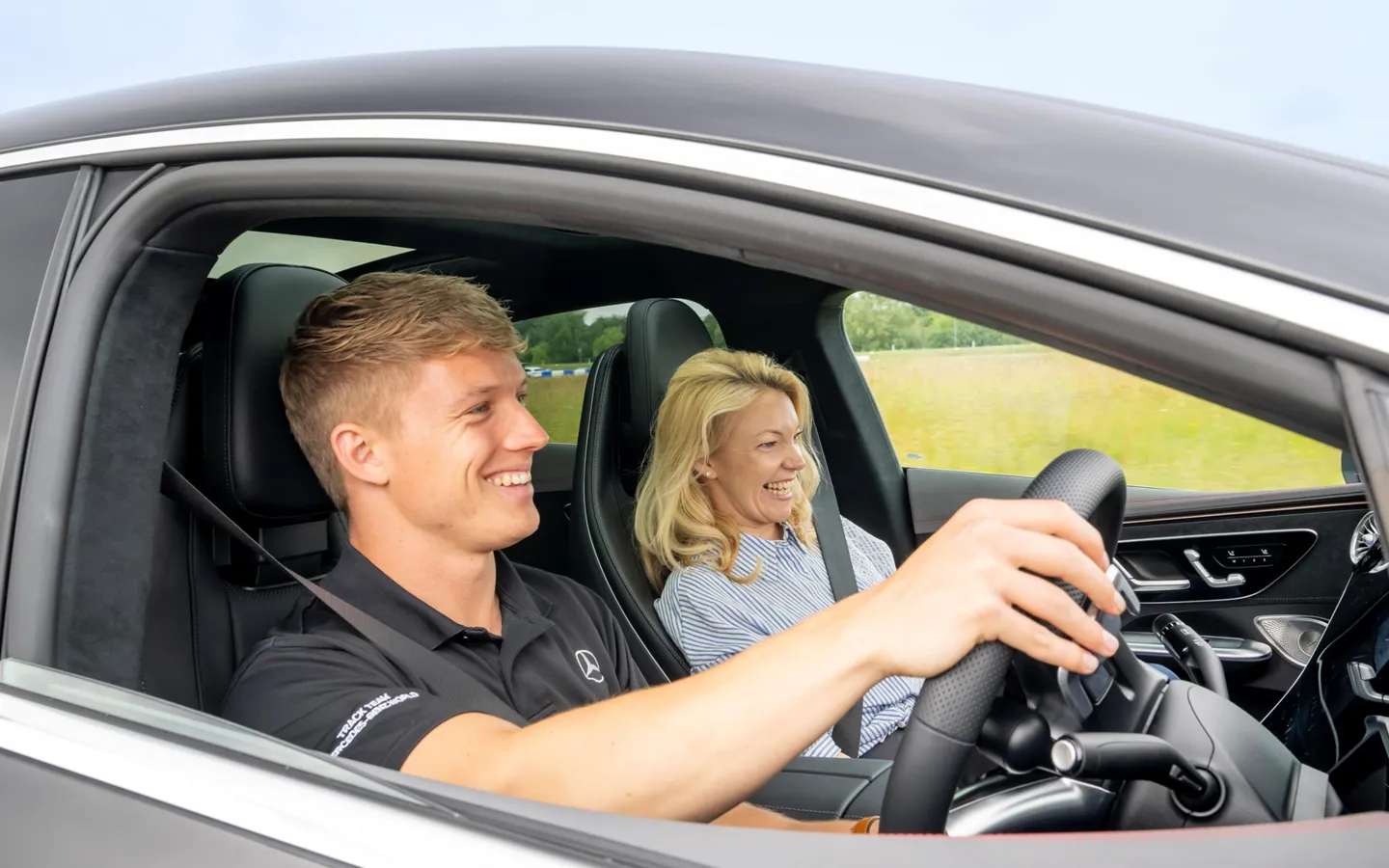 Pro Driver and passenger inside a Mercedes-AMG 63 during a high-speed ride at Mercedes-Benz World, capturing excitement and elite performance.