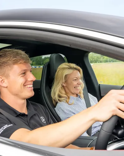 Pro Driver and passenger inside a Mercedes-AMG 63 during a high-speed ride at Mercedes-Benz World, capturing excitement and elite performance.