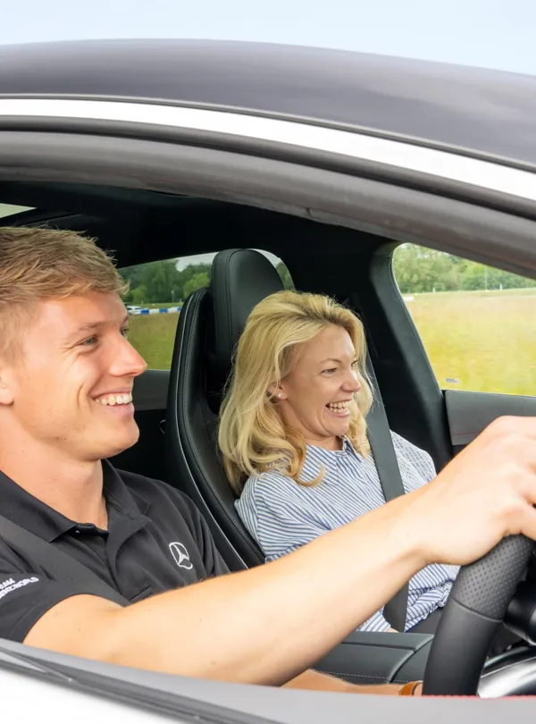 Pro Driver and passenger inside a Mercedes-AMG 63 during a high-speed ride at Mercedes-Benz World, capturing excitement and elite performance.