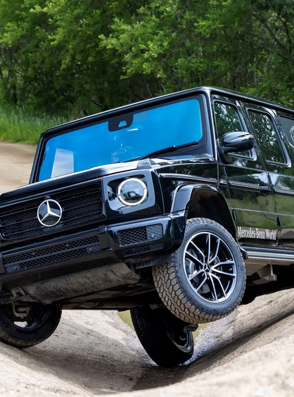 Mercedes-Benz SUV navigating a steep incline on the Off-Road Circuit at Mercedes-Benz World, demonstrating its advanced 4MATIC all-wheel drive system.